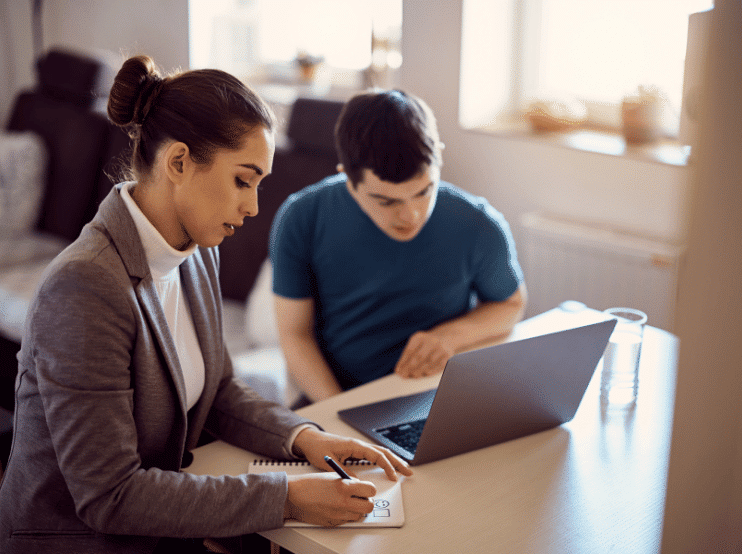 two young ladies looking at a document and talking